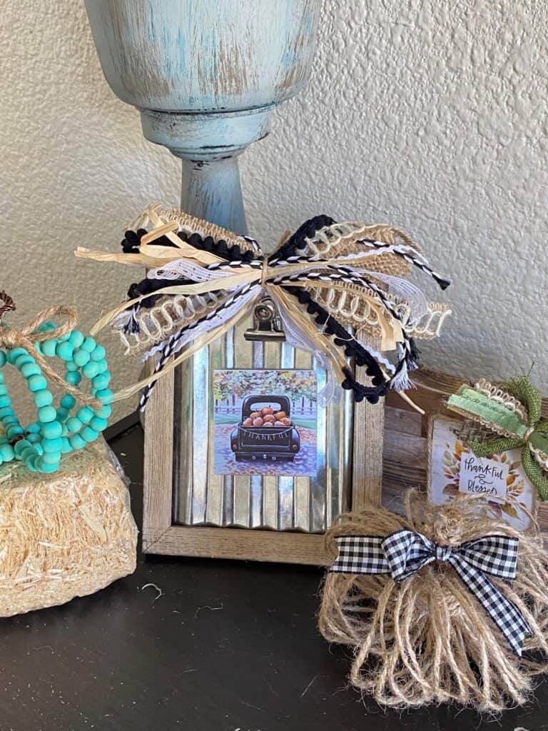 Dollar Tree Back of the Calendar Mini prints interchangeable seasonal frames decor with a fun neutral scrappy bow with raffia all of the other calendar minis with magnets on the back.