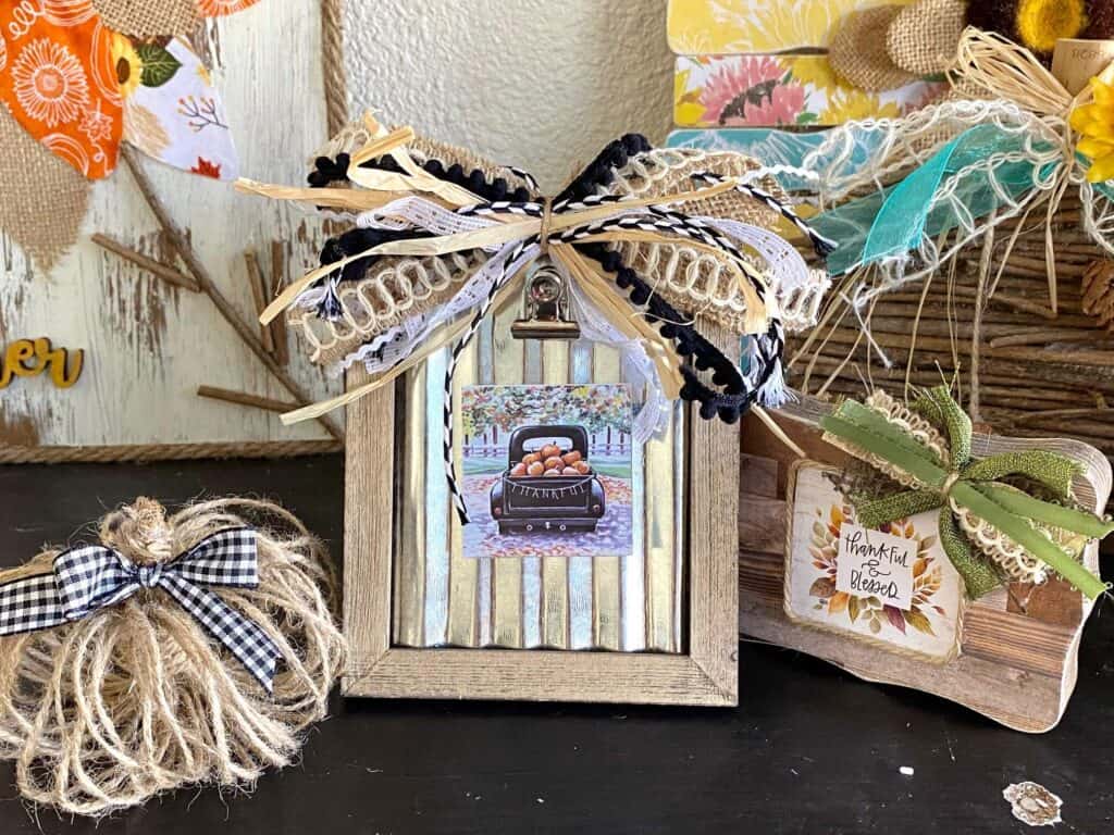 Dollar Tree Back of the Calendar Mini prints interchangeable seasonal frames decor with a fun neutral scrappy bow with raffia and the "Thankful" truck mini print.