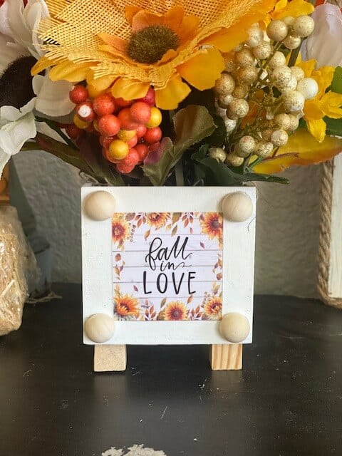 The front of the project showing the "Fall in Love" calendar print glued to the wooden box with half wood beads around it.