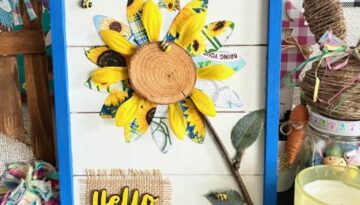 DIY Spring or Summer Fabric Sunflower Decor craft project made with blue and yellow theme sunflower fabric a mini bees and a wooden hello with burlap, in a blue frame.