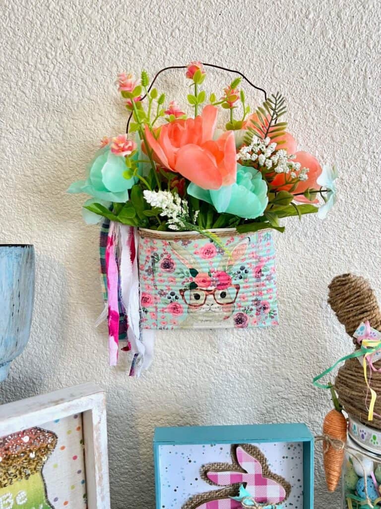 Spring and Easter Bunny upcycled Crushed can decor craft project with a napkin and flowers and rusty wire hanger and a shabby bow, with a twine trim.