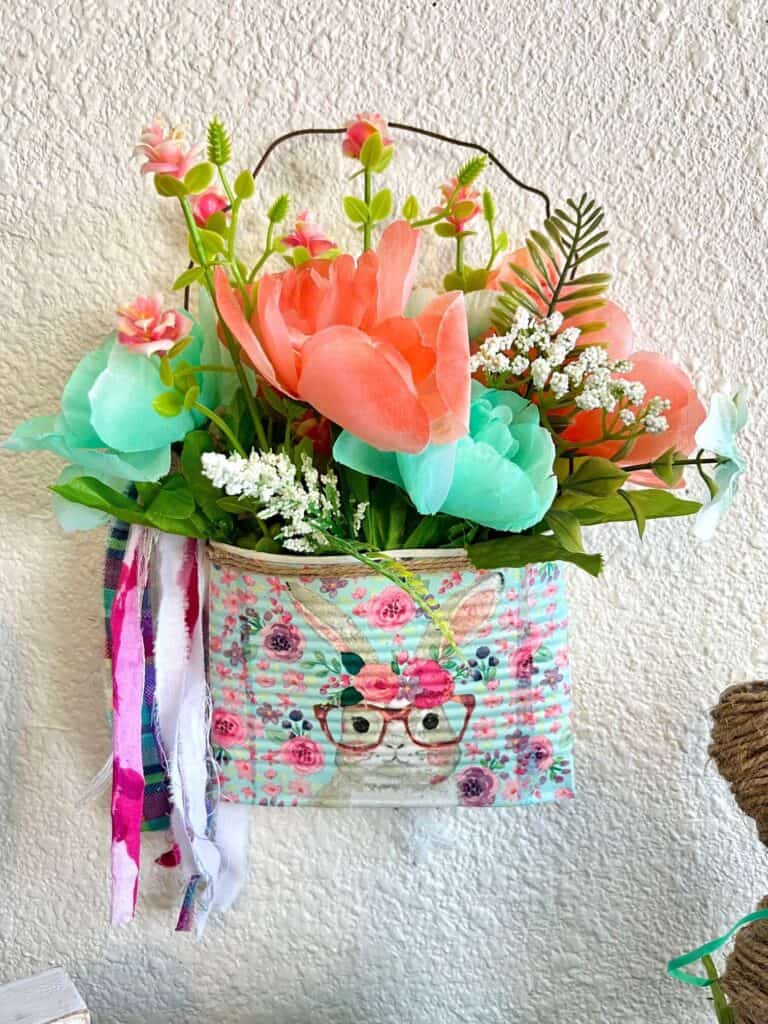 Spring and Easter Bunny upcycled Crushed can decor craft project with a napkin and flowers and rusty wire hanger and a shabby bow, with a twine trim.