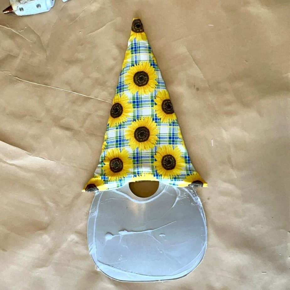 Sunflower fabric wrapped around the gnome hat on the plastic frame.