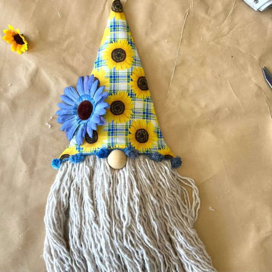 Glue a blue sunflower to the bottom left of the Sunflower Gnome hat.