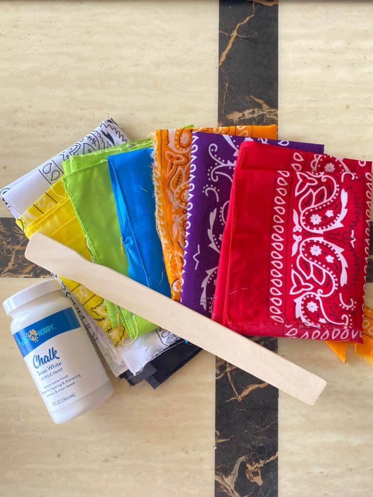 Supplies needed to make a fabric rag flag with rainbow colored bandanas or handkerchief.