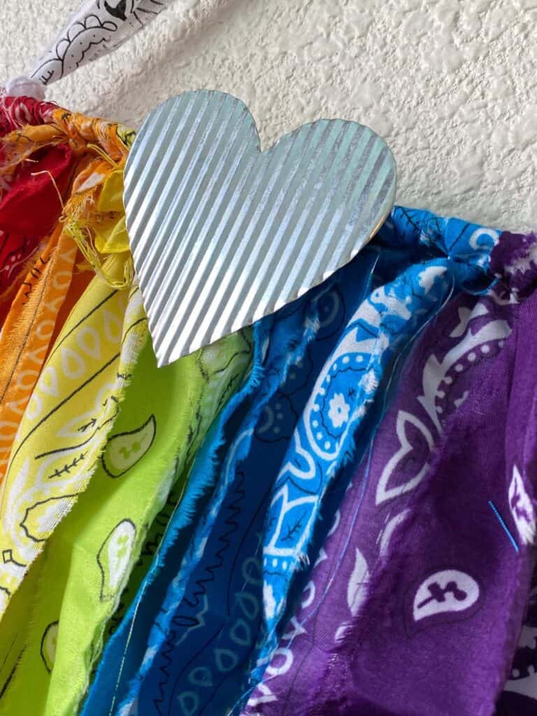 Galvanized Metal heart on the front center of the rainbow rag flag.