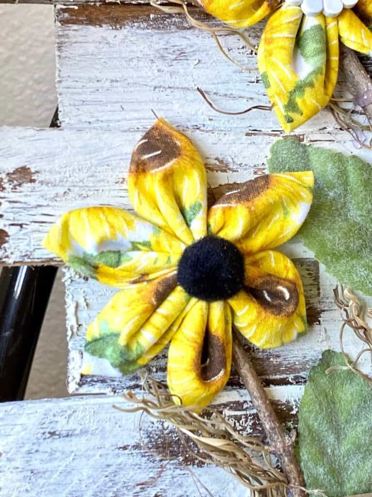 DIY Sewn Fabric Sunflower with yellow sunflower fabric and a black pom pom center.