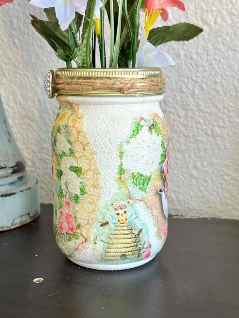 Side of the mason jar with a mini Bumblebee hive on tissue paper Mod Podged to it.