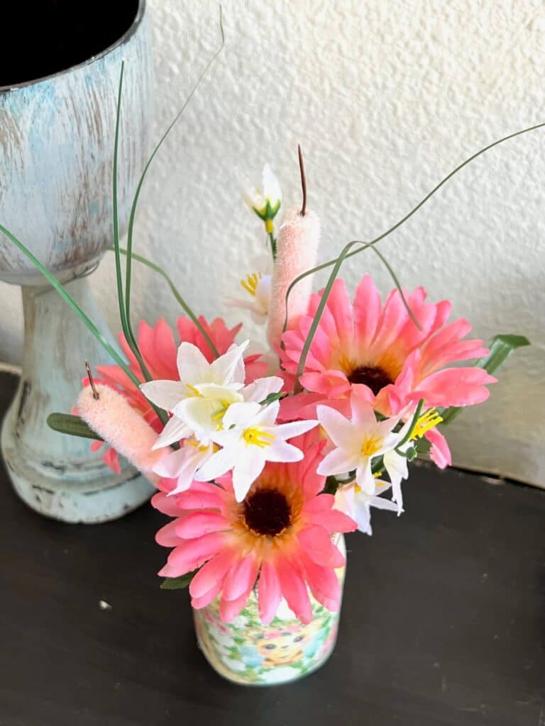 Pink daisies and cat tails, with white delicate florals inside the Mason Jar.