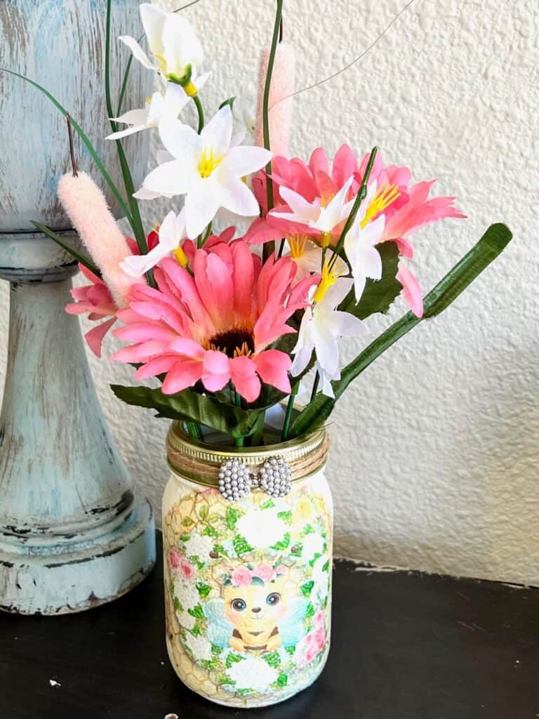 Honey Bee and Sweet Pea craft printable on tissue paper decoupaged to a mason jar with pink and white spring Dollar Tree florals.