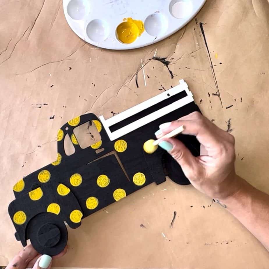 Using a spouncer, cover the entire sunflower truck in yellow polka dots.