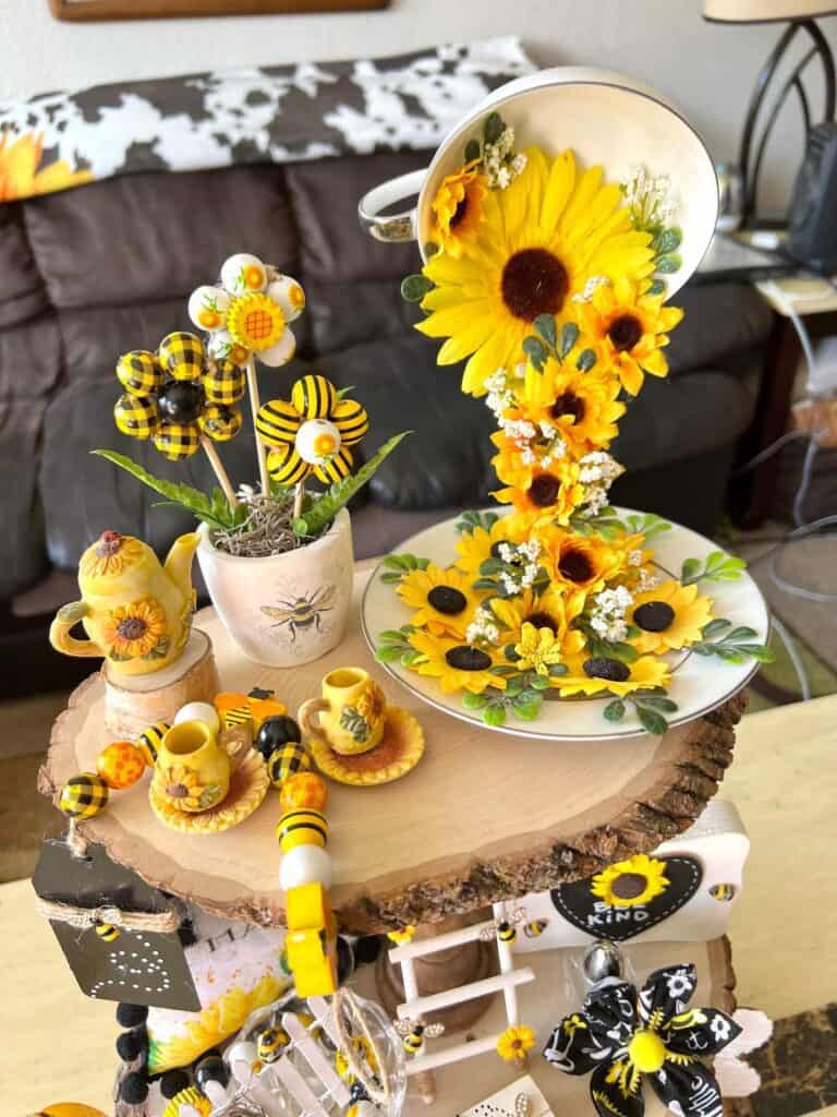 Top tier of the tray with a Sunflower floating teacup, wood bead flowers, and a mini vintage tea set.
