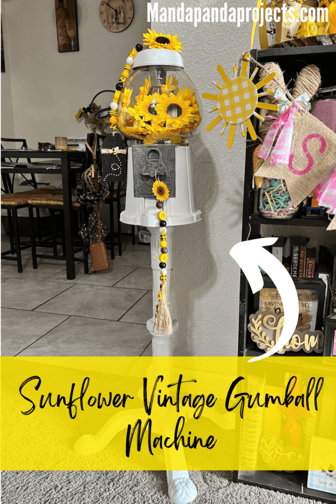 Sunflower Vintage Gumball Machine with sunflower heads inside and on top, and sunflower and bee mini wood bead garlands hanging form the top and coin turner. Gumball machine is painted all white.