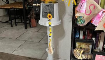 Sunflower Vintage Gumball Machine with sunflower heads inside and on top, and sunflower and bee mini wood bead garlands hanging form the top and coin turner. Gumball machine is painted all white.