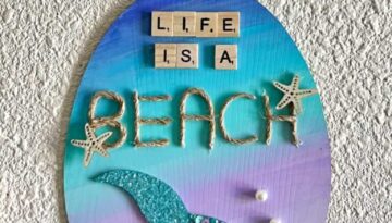 Dollar Tree Ombre Mermaid Tail DIY summer nautical beach decor with "Life is a Beach" written in scrabble tiles and jute twine and a pearl bead hanger.