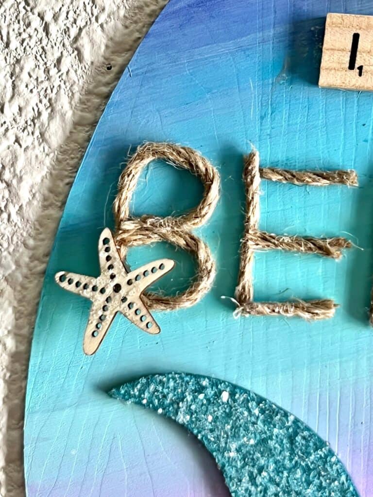 Mini wooden starfish covered in diamond dust glued to the letter "B" in jute twine.