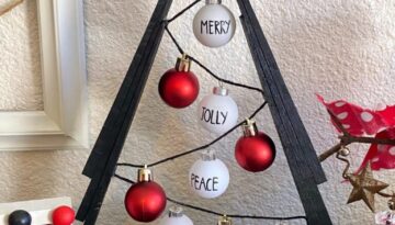 Black A frame wooden shim Christmas Tree with small red and white Rae dunn inspired bulb ornaments on black string.