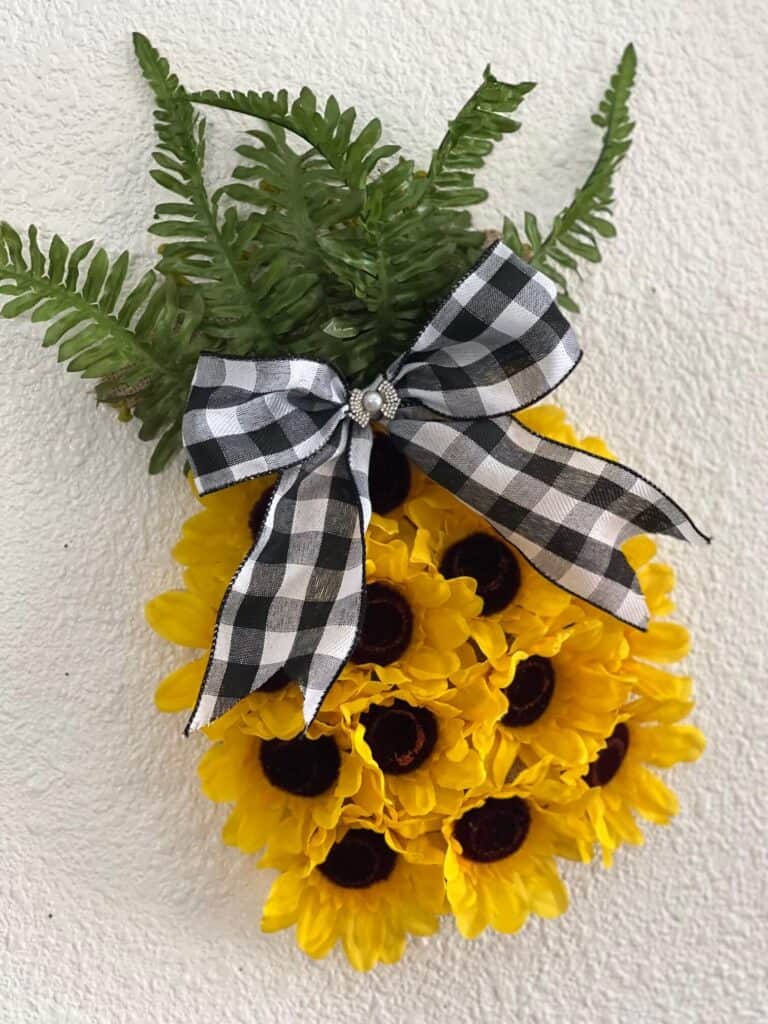 Dollar Tree Sunflower Pineapple Door Hanger DIY decor for summer crafts with a large buffalo check bow and mini bling.