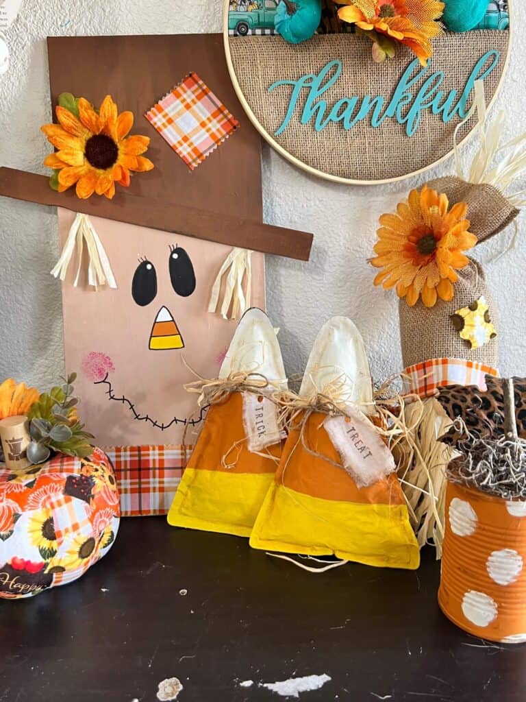 The completed Brown Kraft Paper Candy corn staged and decorated with other fall DIYs and decor pieces on a bookshelf.