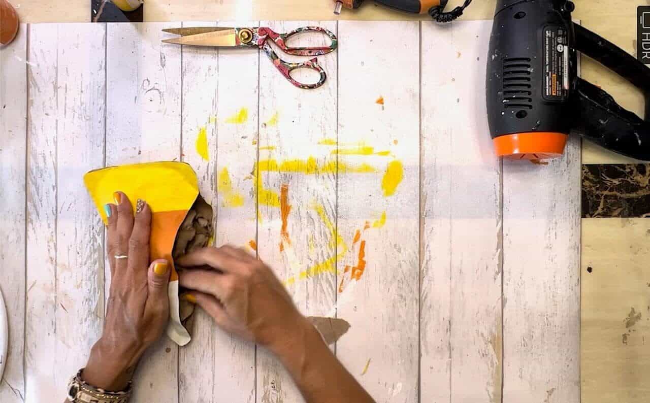 Stuffing the candy corn with crumpled up brown Kraft paper.