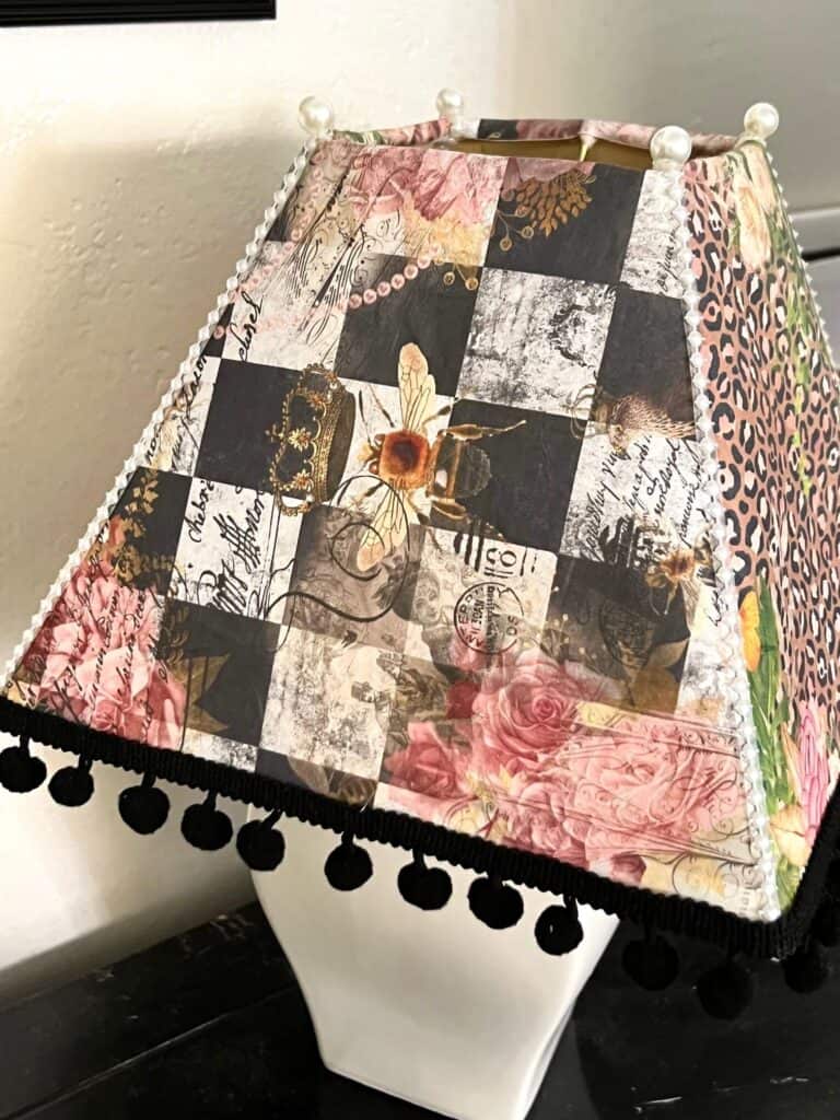 The one side of the lampshade with the "Royal Funky Queen Bee" rice paper printable decoupaged to it. I has black and white checks with a bee with a crown on its head and roses.