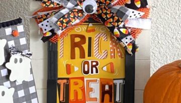 DIY Dollar Tree Trick or Treat Frame made with a Halloween card and a huge messy bow with candy corn, orange, black, and a jumbo googly eye in the center.