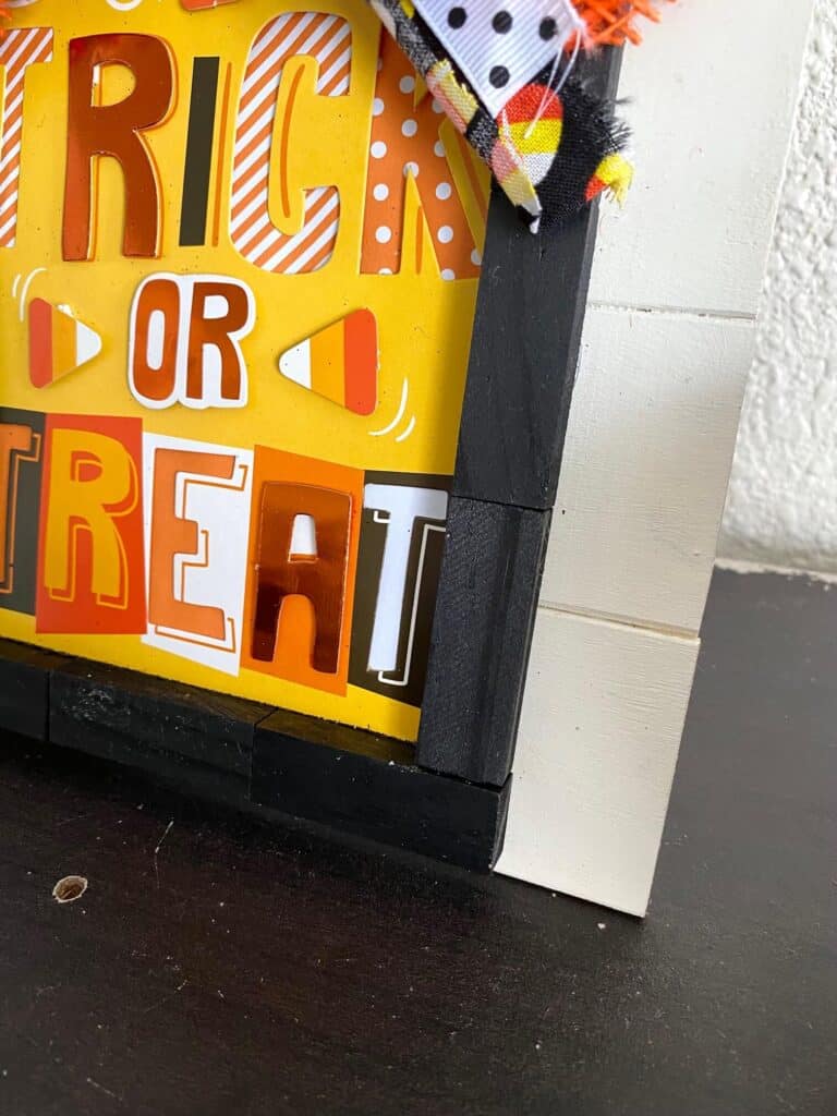 The jenga blocks painted black and outlining the Trick or Treat card as if it were a frame.