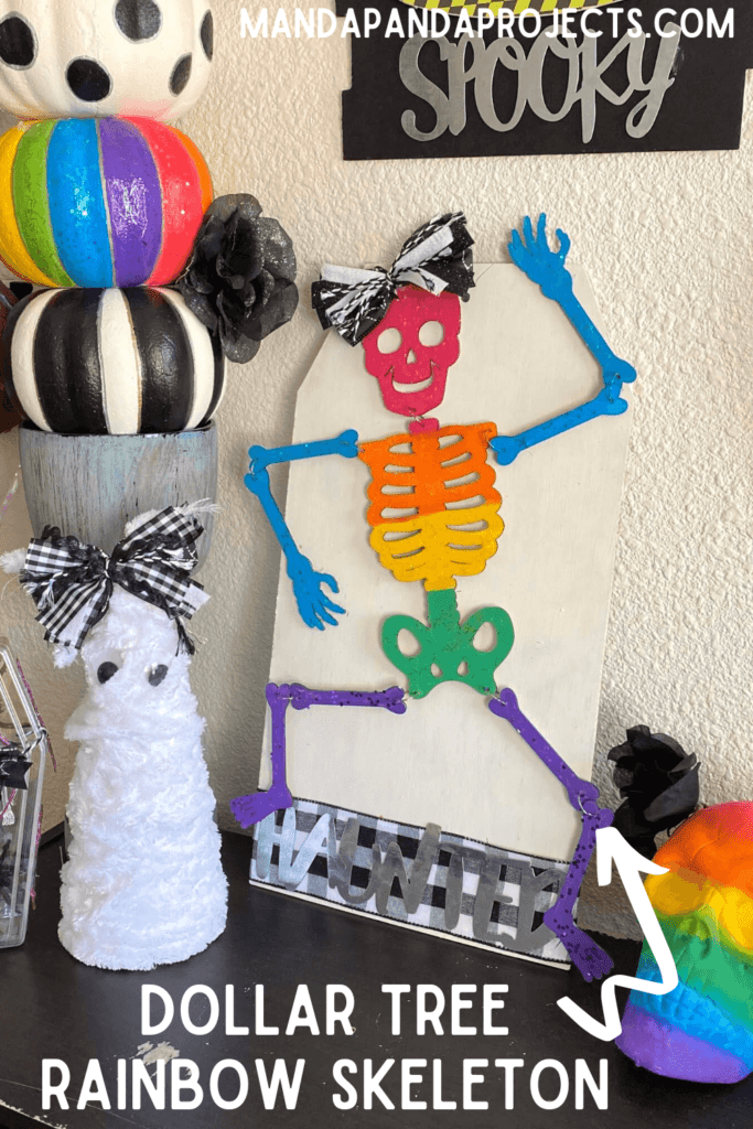 DIY Dollar Tree Rainbow Halloween Skeleton with a haunted sign and a black and white cute bow for your DIY decorations.