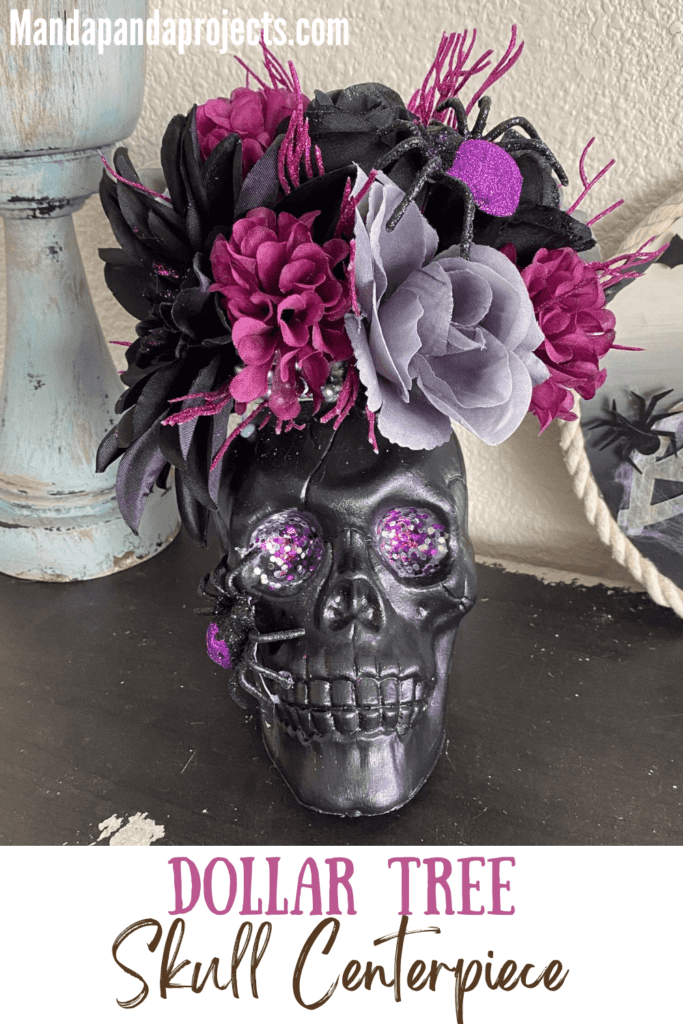 Dollar Tree Halloween Skull centerpiece with black skull, purple glitter eyes, a black and purple sparkly spider, and black, grey, and purple flowers for a spooky and glam piece of DIY Halloween decor for a home or a party.