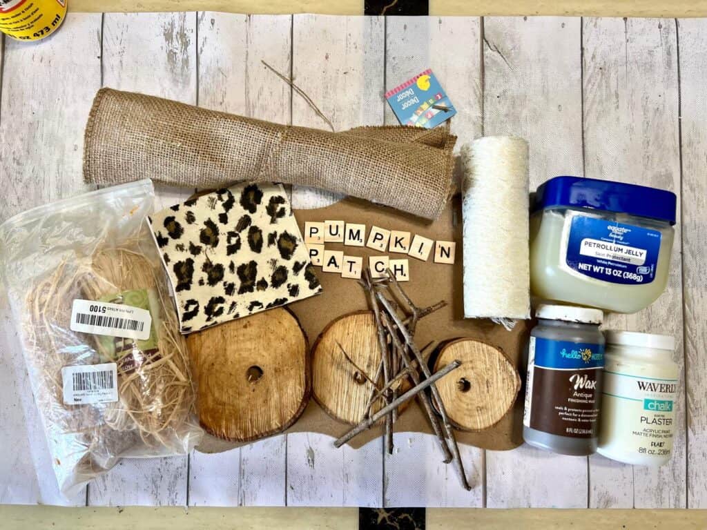 Supplies needed to make a rustic leopard pumpkin patch with wood rounds, lace, leopard napkin, and burlap.