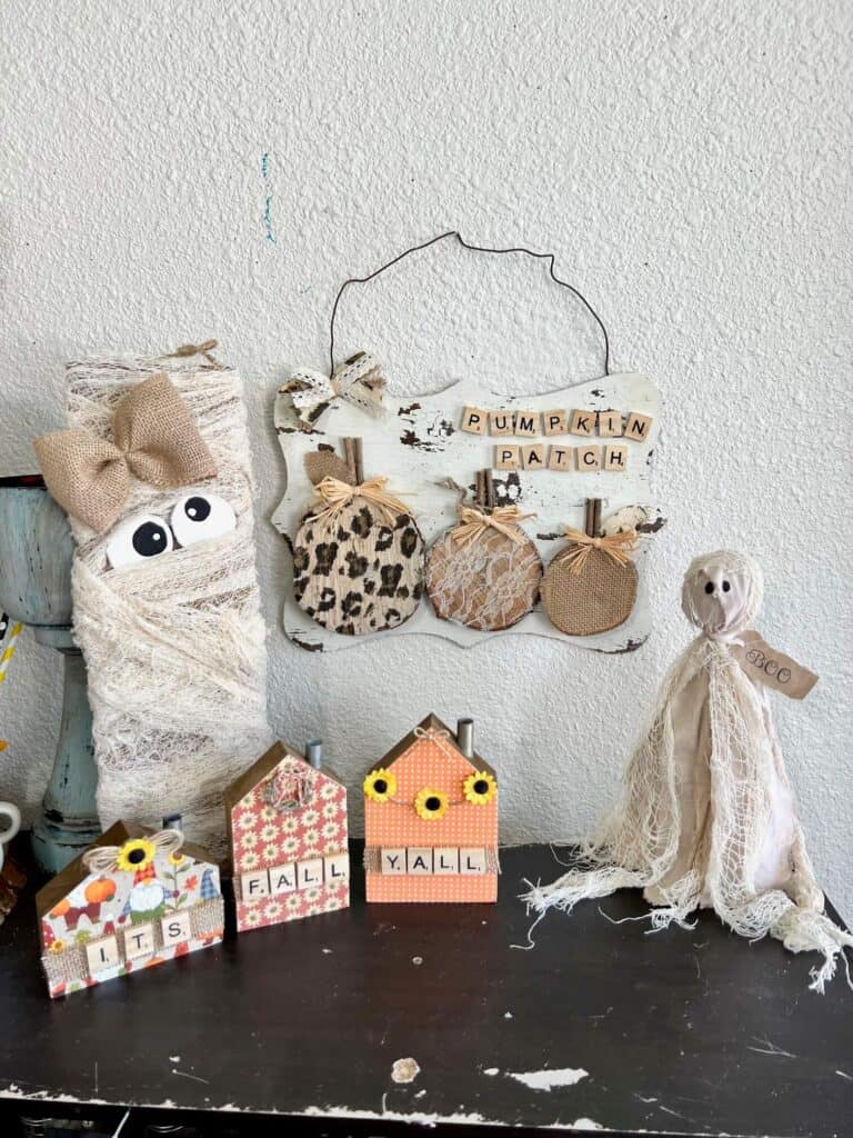 The completed and staged Pumpkin patch project displayed next to a Mummy, ghost and fall decorated houses on a bookshelf.