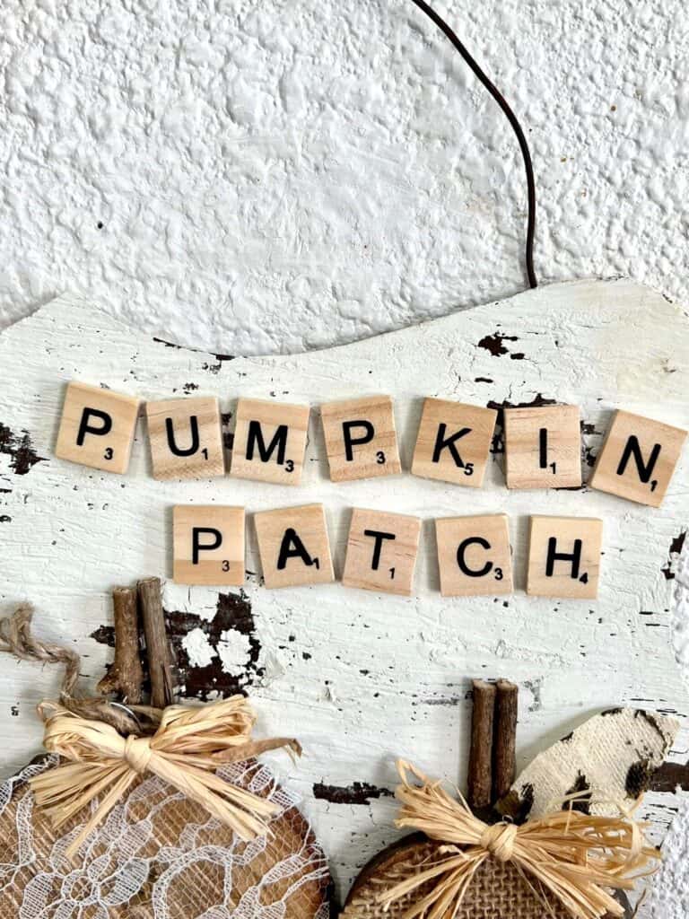 The words pumpkin patch spelled out with scrabble tiles on the top right of the craft.