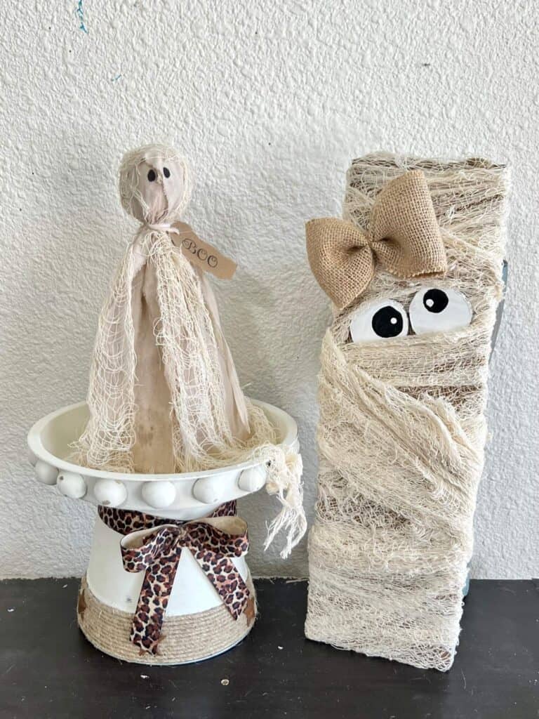 The completed primitive ghost project on a decorative riser next to a cheesecloth Mummy.