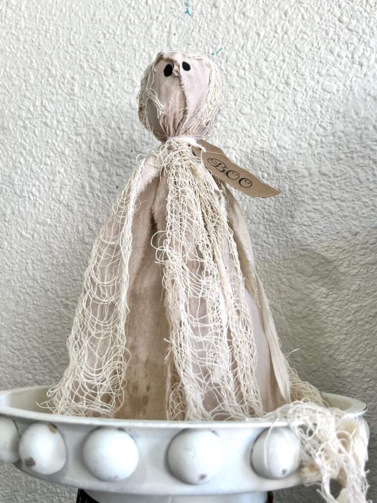 DIY Primitive Halloween Rag Ghost made with creepy cheese cloth and muslin that is stained with antique wax to look grungy with a hangtag around his neck that says "BOO".
