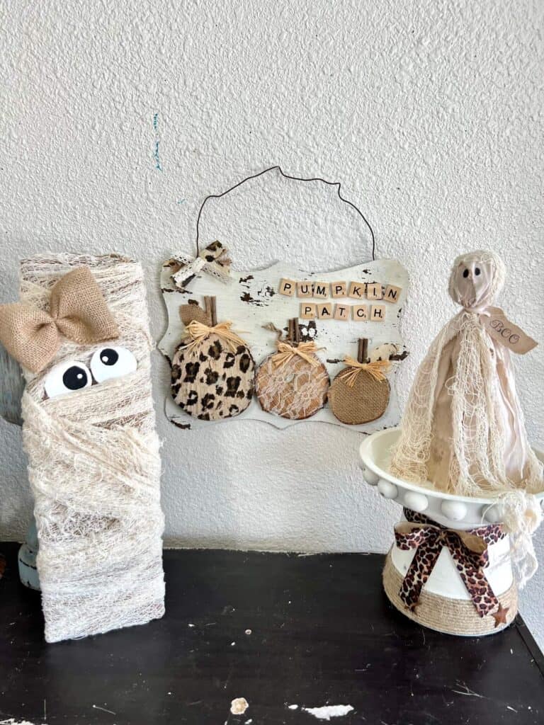 Rustic leopard, lace, and burlap pumpkin patch next to a cheesecloth Mummy and a primitive ghost on a bookshelf.