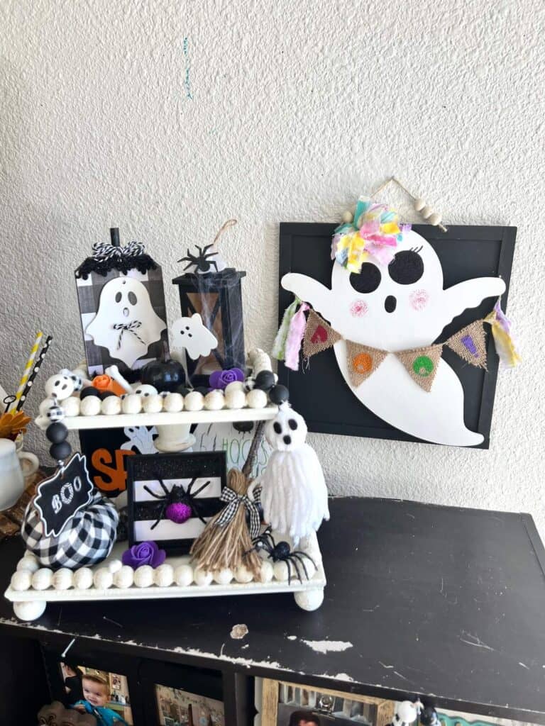 Dollar Tree Rainbow Ghost with a burlap banner next to a white tiered tray thats decorated for Halloween.