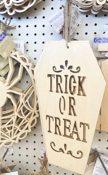 Plain wooden trick or treat coffin hanging up inside the Dollar Tree store.