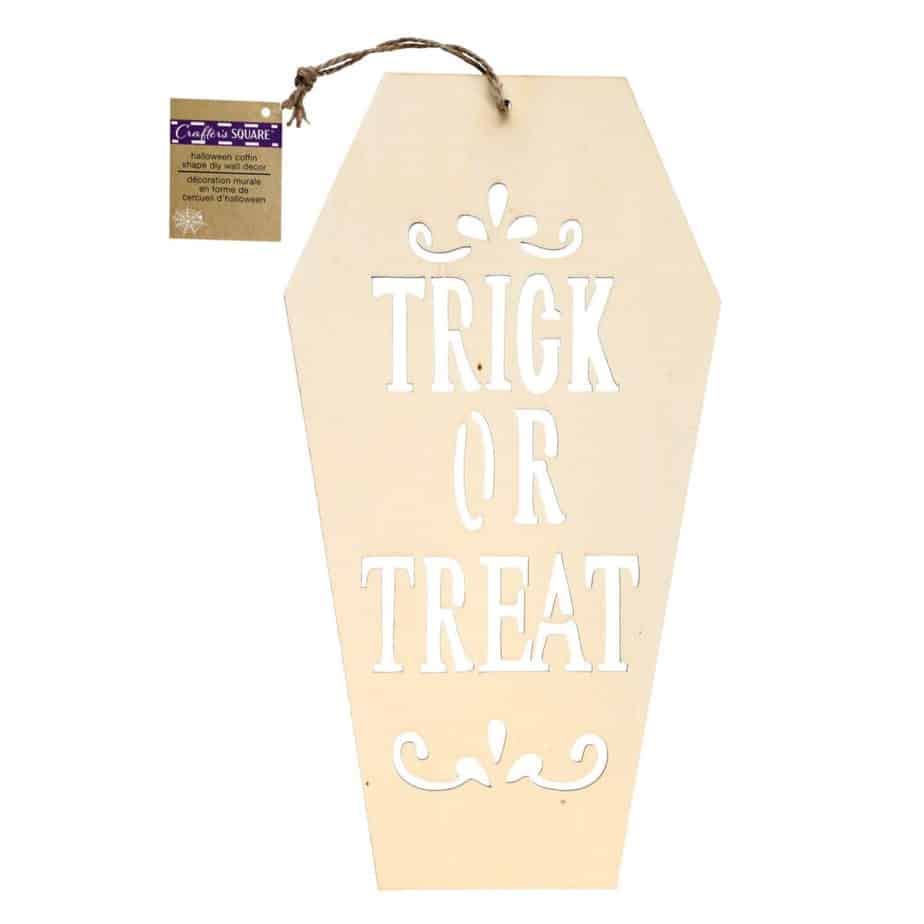 Plain wooden coffin with the words Trick or Treat cut out of it and a Dollar Tree Crafters square tag.