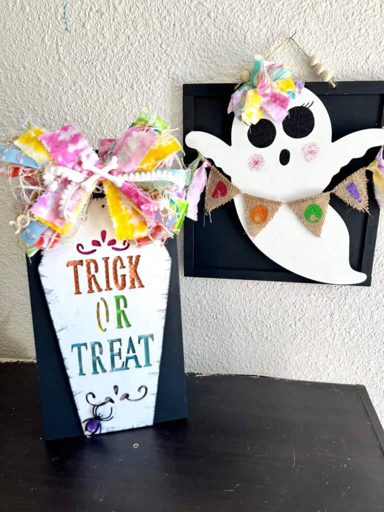 The completed and staged Rainbow Trick or Treat coffin on a bookshelf next to a Dollar Tree wood ghost holding a burlap BOO banner.