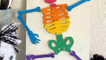 DIY Dollar Tree Rainbow Halloween Skeleton with a haunted sign for your DIY decorations.