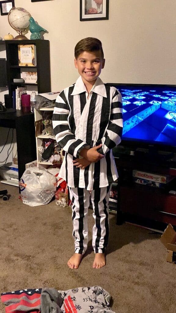 Maddox standing in the Black and white striped DIY Beetlejuice Halloween suit.