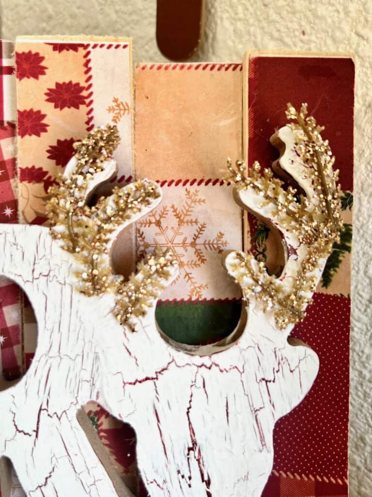 The wooden deer at the end of the word merry with gold glitter branches glued to the antlers.