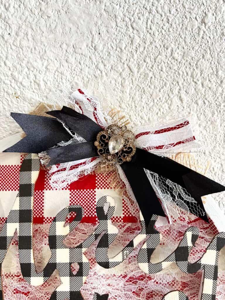Small messy bow with red and white striped ribbon , black ribbon, and a Totally Dazzled bling in the middle.