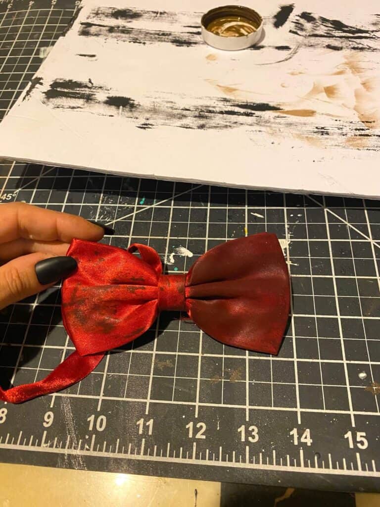 Dirtying and grudging up a maroon bowtie with antique wax.