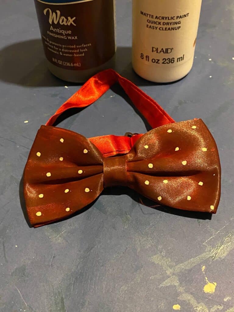 Grungy maroon bow tie with grey polka dots.