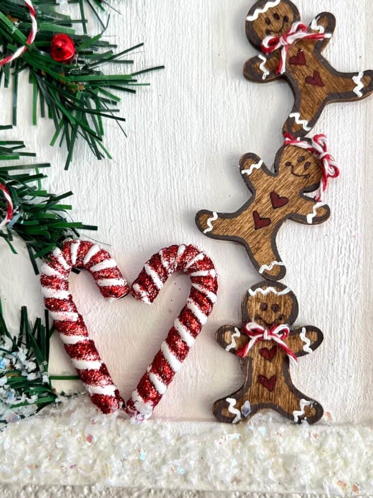 2 candy canes glued together in the shape of a heart at the bottom of the Christmas Tree next to the Gingerbread Men.