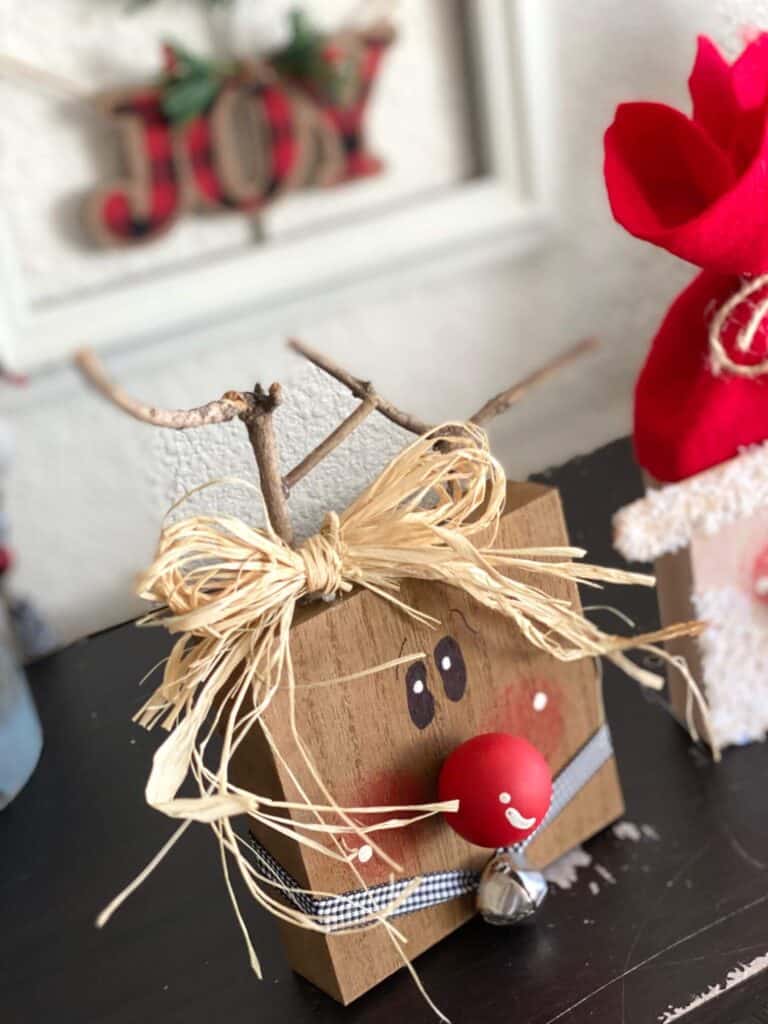 The reindeer with a big raffia bow at the base of his antlers that are made with sticks.
