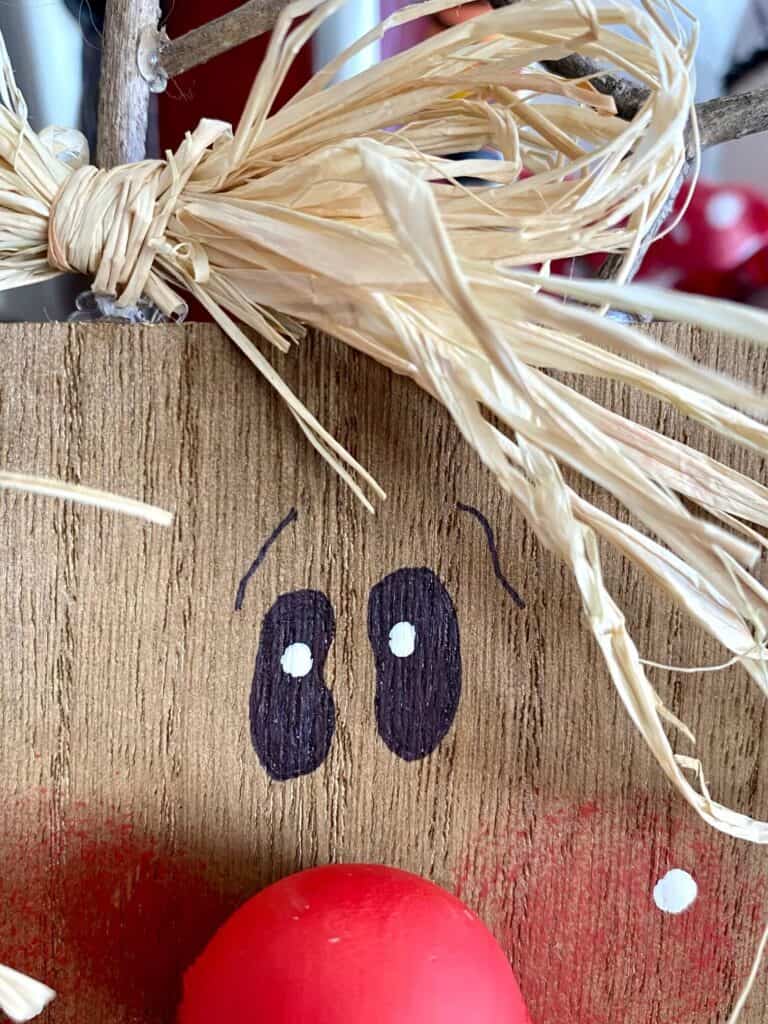 Close up of the wood block reindeers eyes painted with marker.