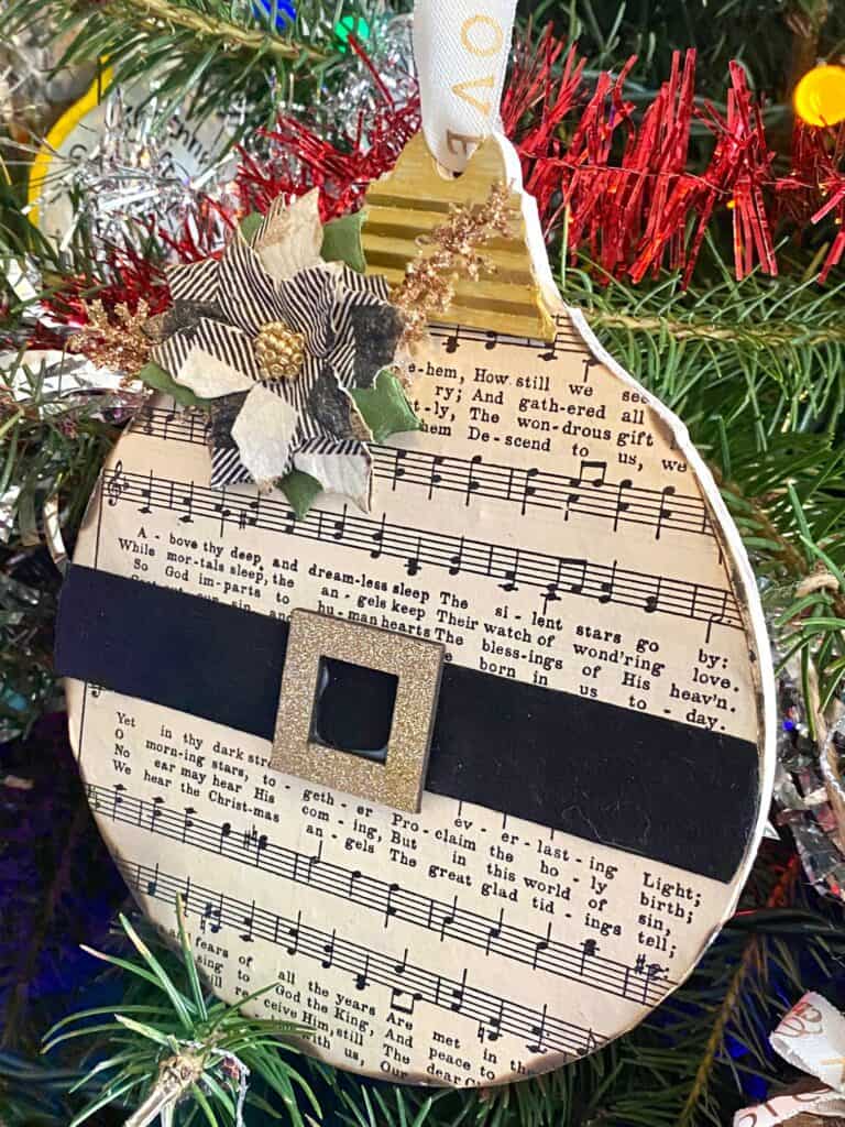 Mod Podge the music sheet paper to the wood ornament and glue the santa belt over the center.
