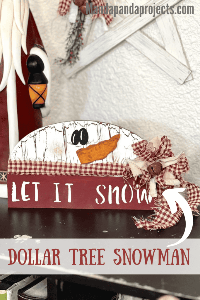 Dollar Tree half wood snowman with white paint and crackle paint underneath, cardboard carrot nose, homespun fabric scarf and bow, and the bottom portion is dark red and say let it snow.